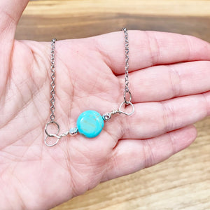 Single howlite coin pendant in hand
